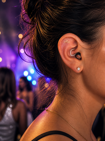 Roam Everyday Invisible earplug demonstrated Close-up in a person's ear with multiple earrings against a blurred background